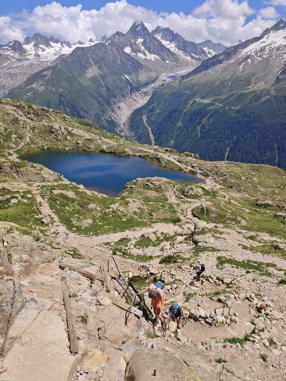 Escursionisti sulle scale sopra i lacs des Chéserys, con il glacier d'Argentière sullo sfondo