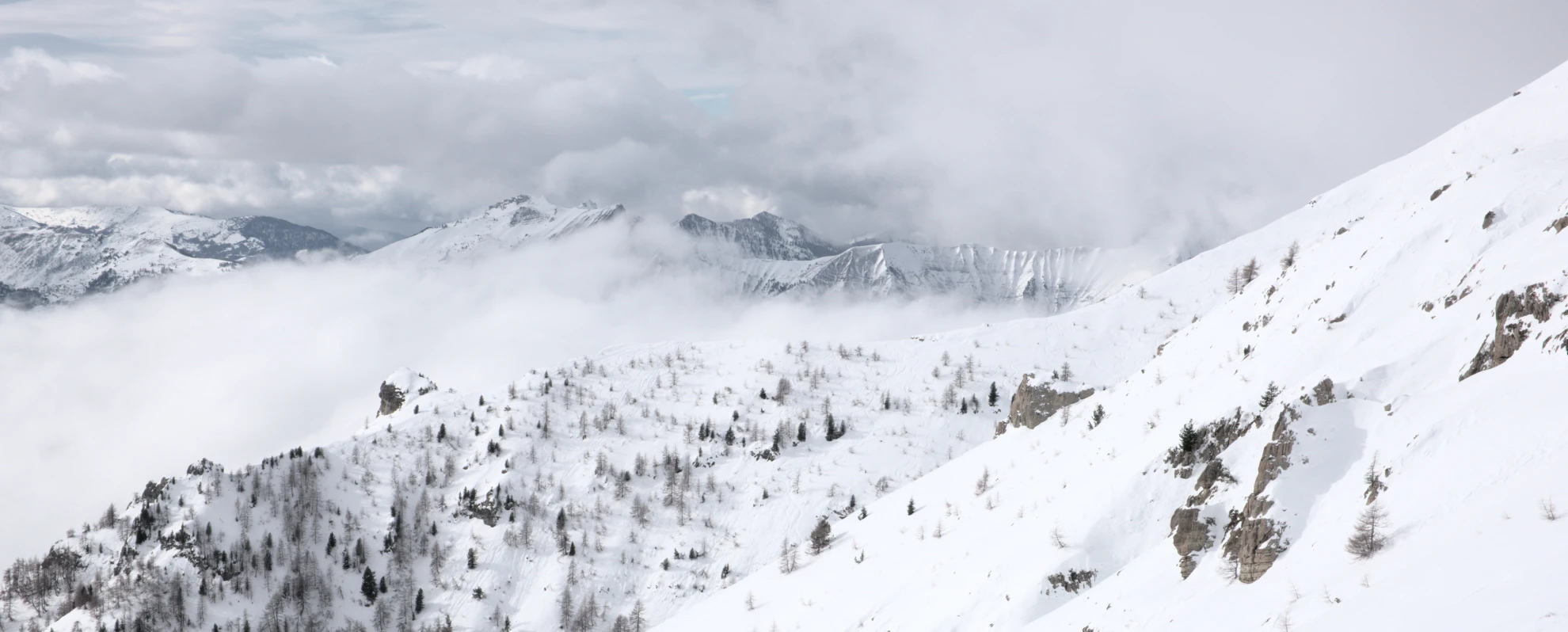 Versante innevato del Vieux Chaillol sopra un mare di nuvole